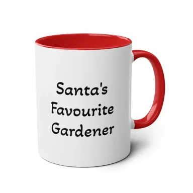 Santa's favourite gardener mug white ceramic coffee mug with a holly tree in a plant pot outside in the snow.